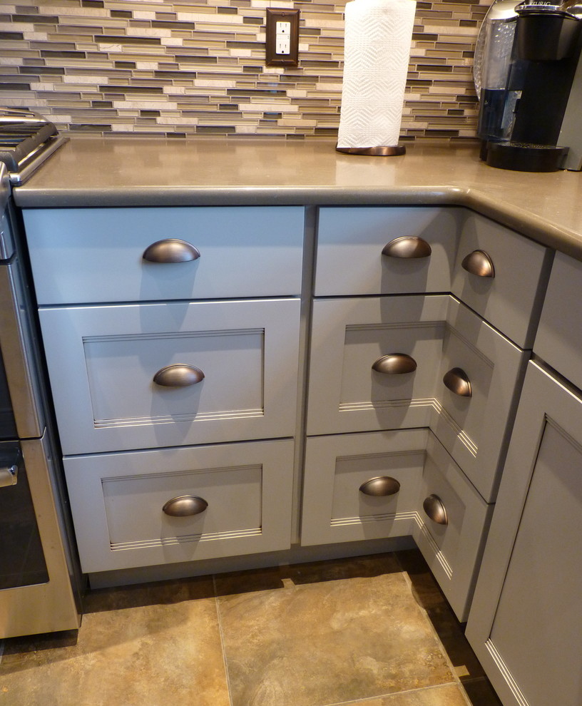 Home design - large transitional u-shaped porcelain tile and beige floor home design idea in Philadelphia with a farmhouse sink, shaker cabinets, gray cabinets, quartz countertops, gray backsplash, mosaic tile backsplash, stainless steel appliances and an island