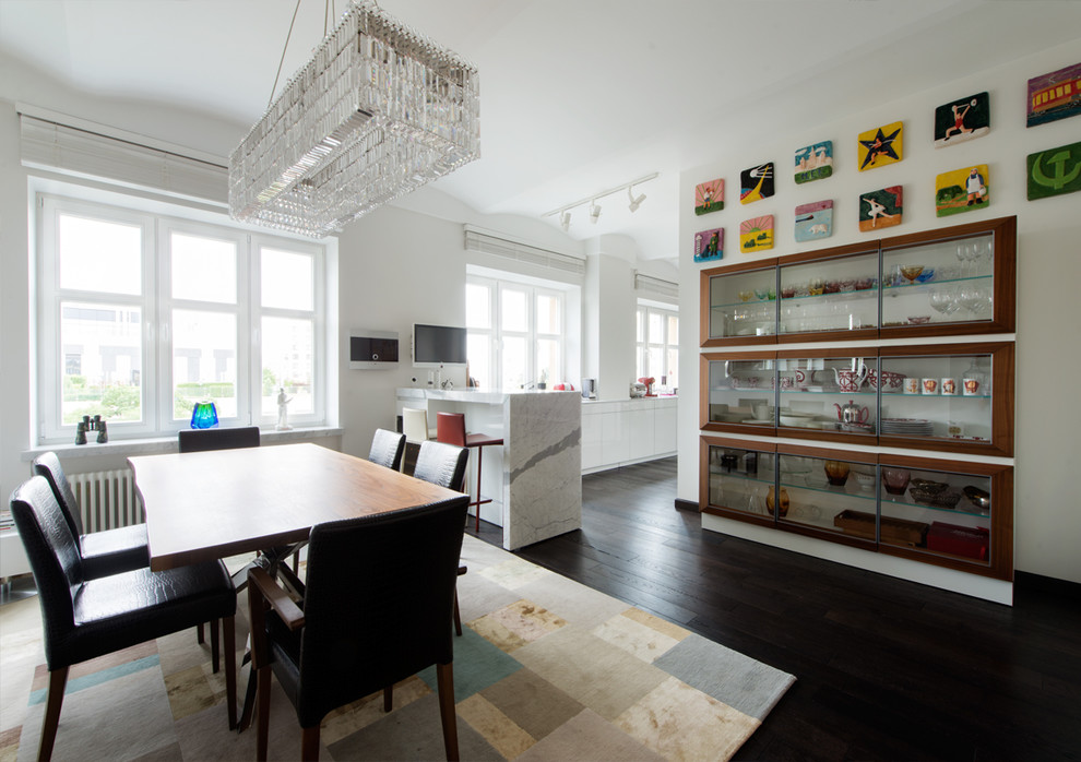 Inspiration for a large contemporary galley eat-in kitchen in Moscow with dark hardwood floors, black floor, flat-panel cabinets, white cabinets, glass benchtops, white splashback, white appliances, with island and white benchtop.