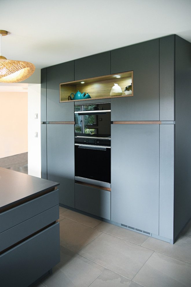 Inspiration for an expansive contemporary galley open plan kitchen in Nancy with with island, a single-bowl sink, open cabinets, grey cabinets, panelled appliances, ceramic floors and grey floor.