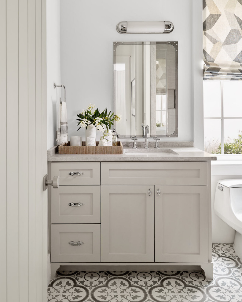 Beach Bungalow - Inspiration for a small coastal 3/4 white tile ceramic tile, gray floor and double-sink freestanding bathtub remodel in Houston with recessed-panel cabinets, white cabinets, a one-piece toilet, white walls, a drop-in sink, a hinged shower door, gray countertops and a built-in vanity
