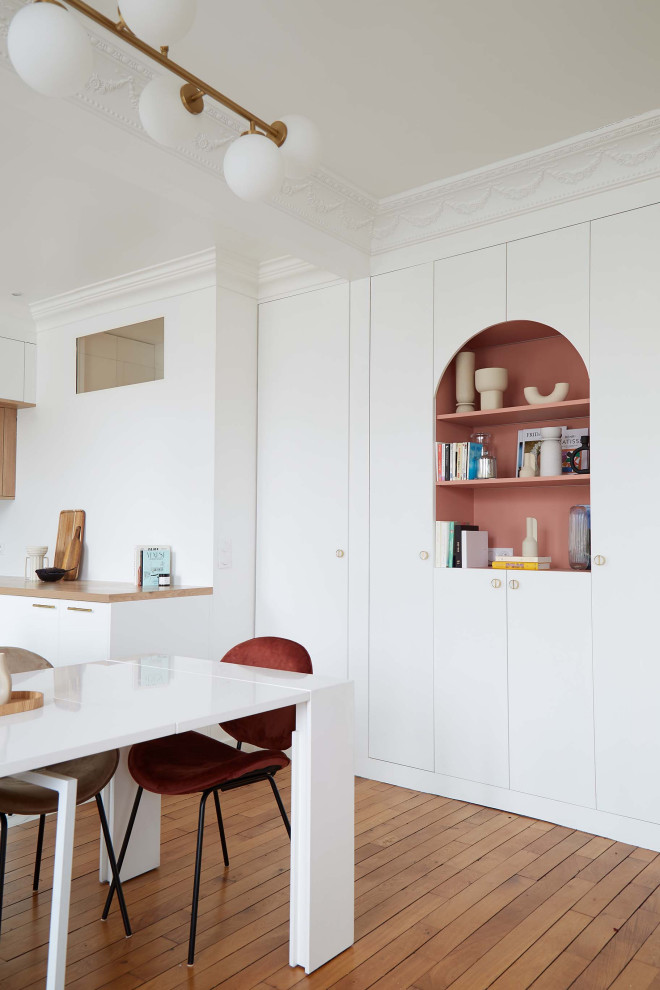 Idées déco pour une salle à manger scandinave avec un sol en bois brun et un mur rose.