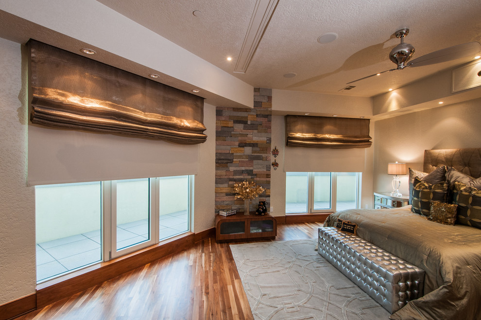 Large contemporary master bedroom in Dallas with beige walls and light hardwood floors.