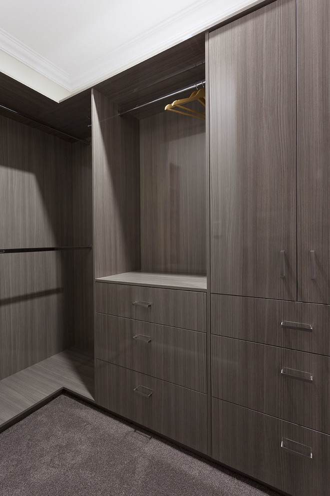 Inspiration for a traditional gender-neutral walk-in wardrobe in Perth with dark wood cabinets, carpet and grey floor.