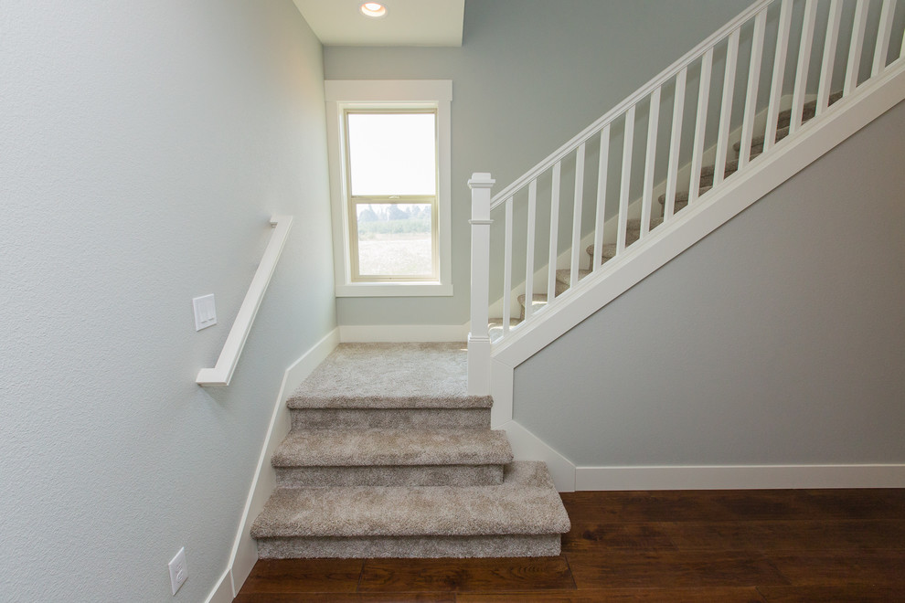 Small traditional carpeted l-shaped staircase in Portland with carpet risers and wood railing.