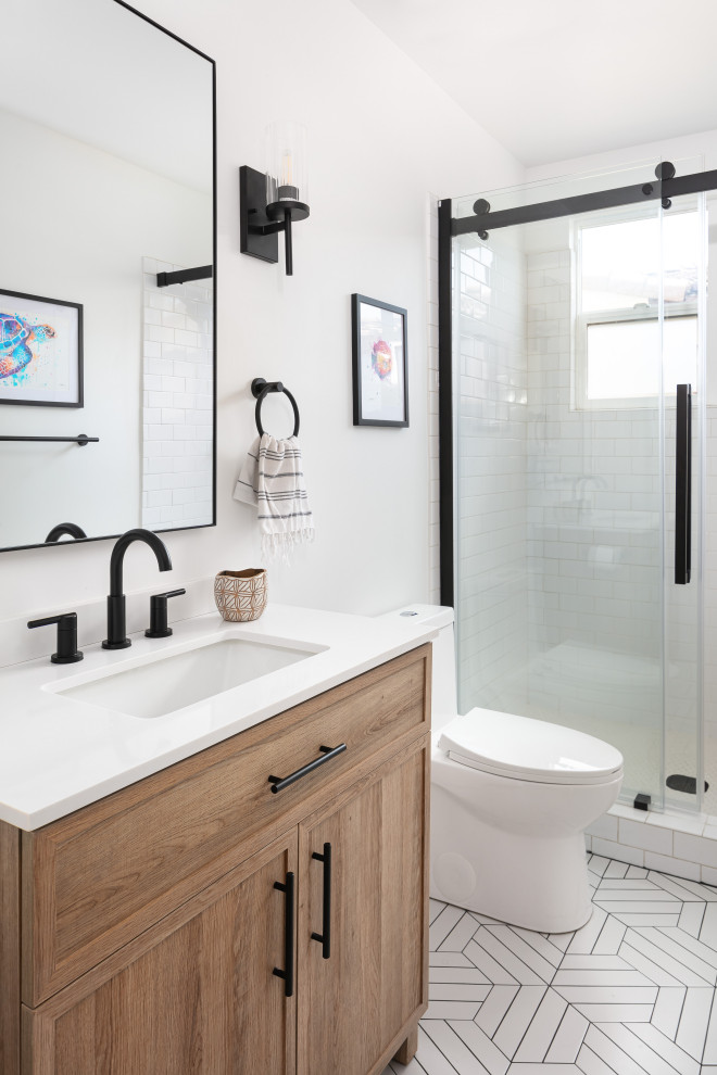 This is an example of a small country 3/4 bathroom in Los Angeles with shaker cabinets, medium wood cabinets, an alcove shower, a two-piece toilet, white tile, subway tile, white walls, concrete floors, an undermount sink, engineered quartz benchtops, white floor, a sliding shower screen, white benchtops, a single vanity and a freestanding vanity.
