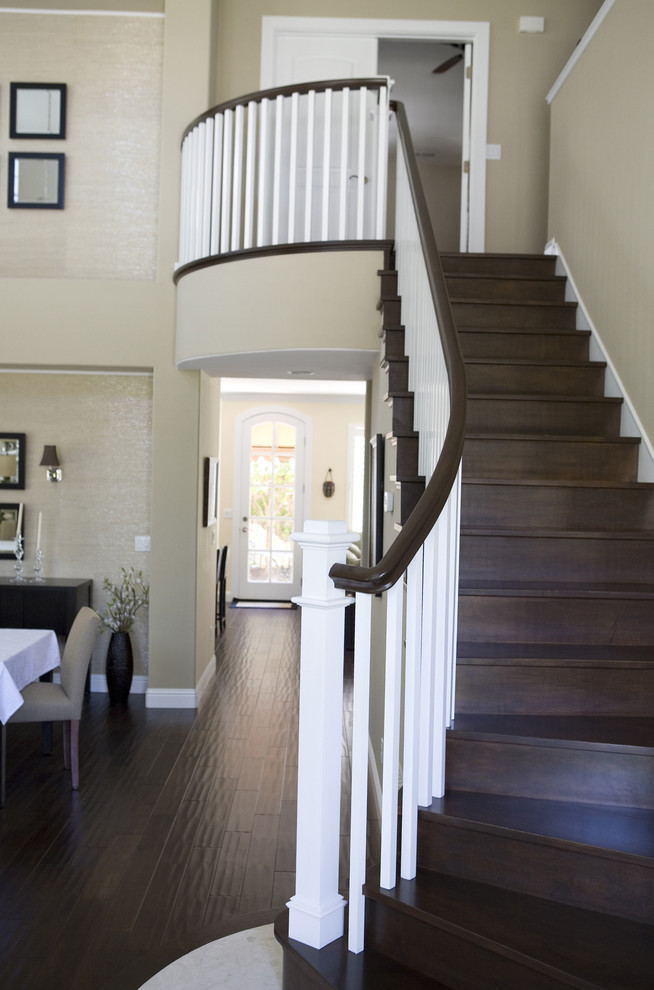Photo of a large traditional wood curved staircase in San Francisco with wood risers.