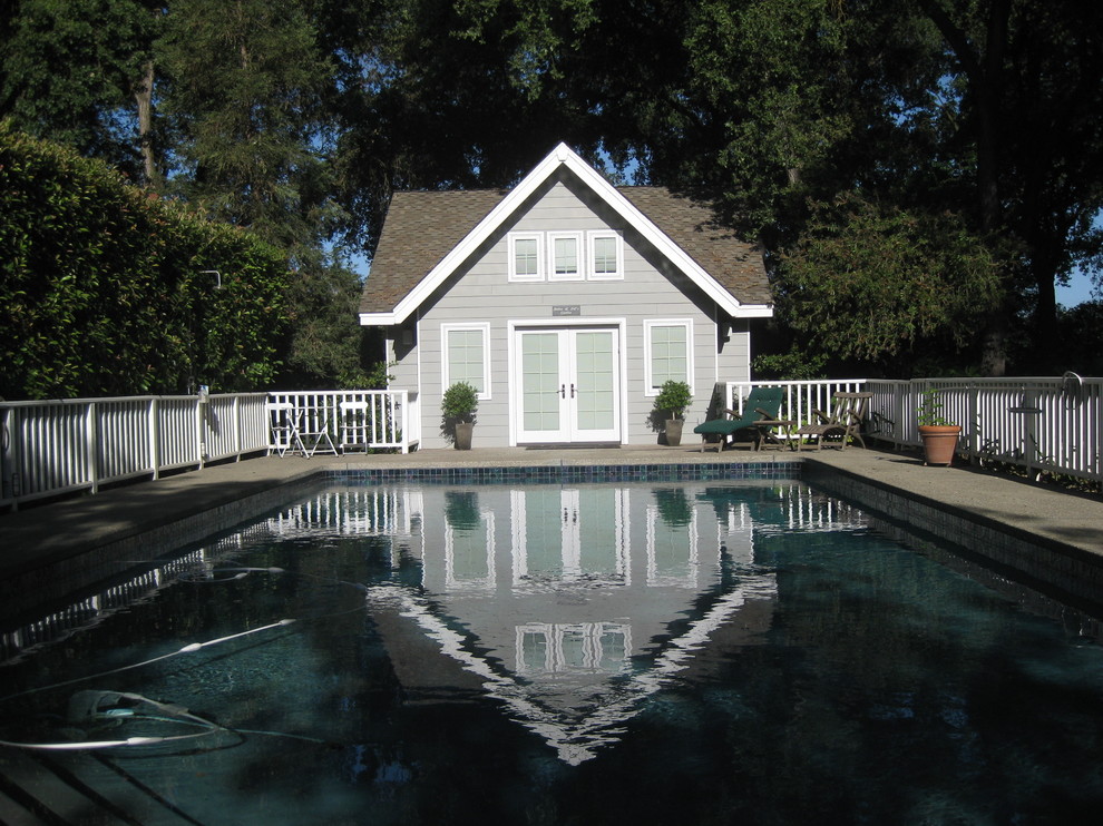 This is an example of a small eclectic backyard rectangular lap pool in Other with a pool house and concrete slab.