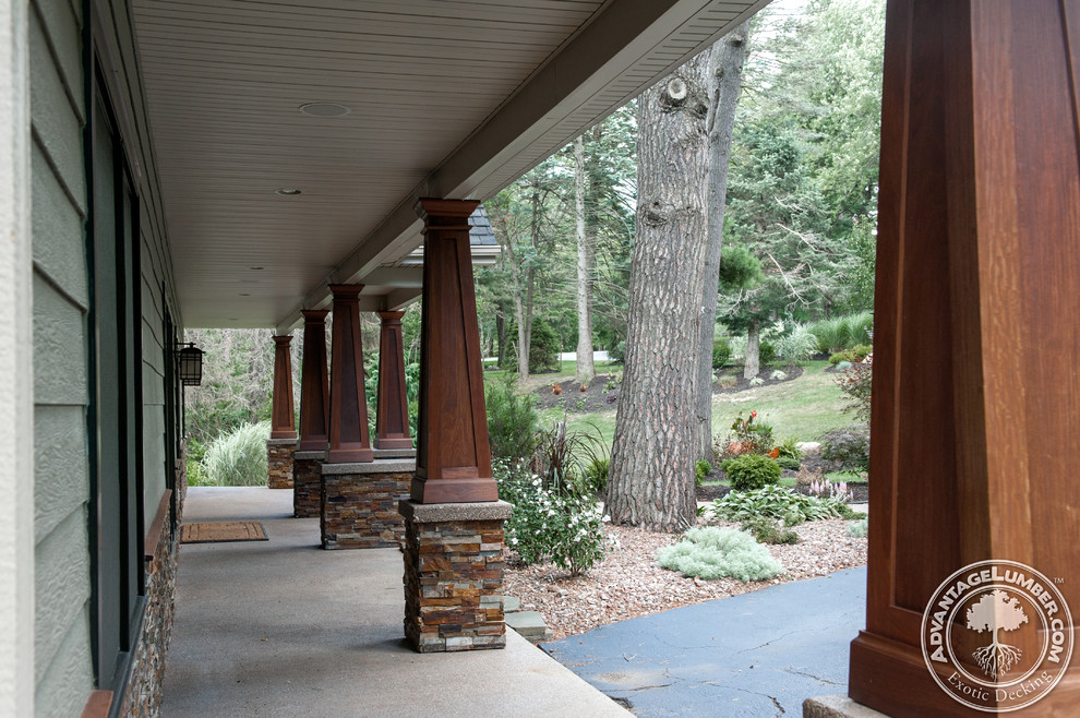 Photo of a mid-sized arts and crafts front yard verandah in New York with concrete slab.
