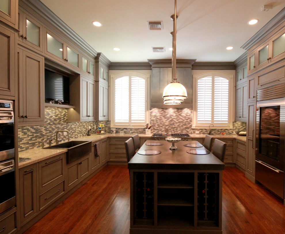 Large transitional l-shaped dark wood floor and brown floor enclosed kitchen photo in Miami with a farmhouse sink, recessed-panel cabinets, gray cabinets, granite countertops, multicolored backsplash, mosaic tile backsplash, stainless steel appliances and an island
