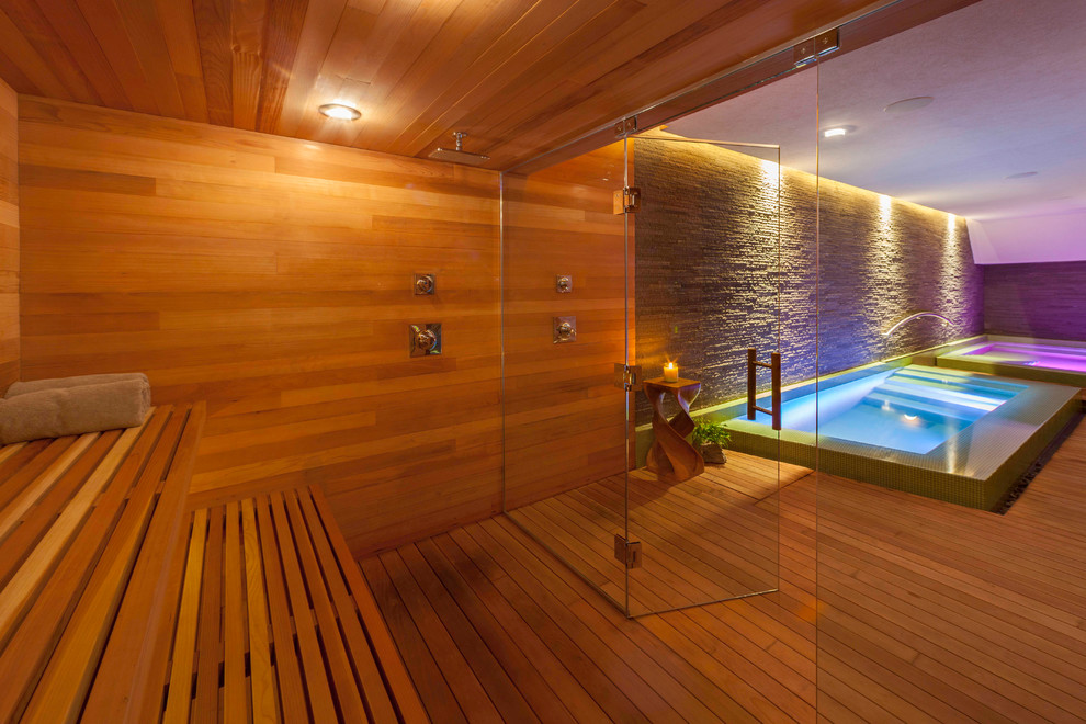 Photo of a contemporary indoor pool in Other with a hot tub and decking.
