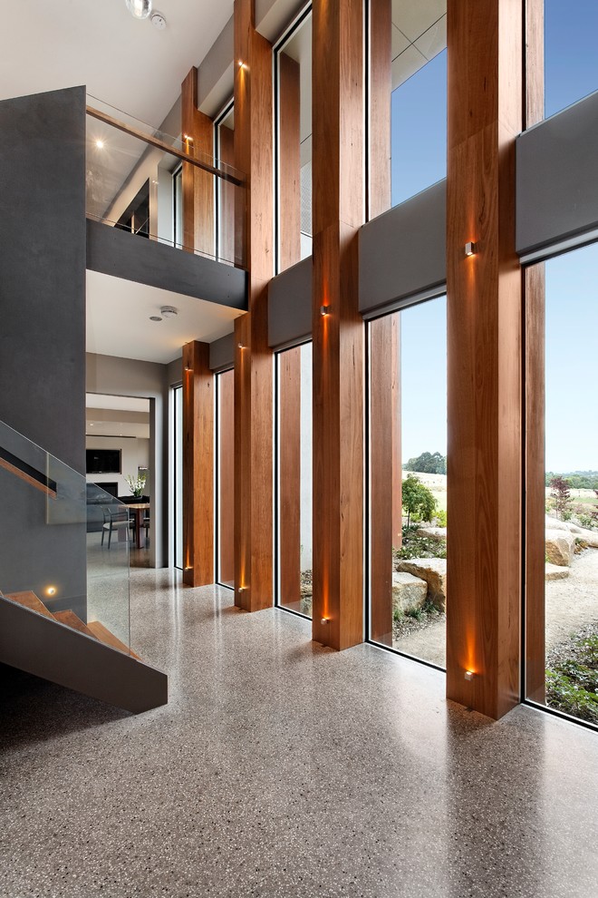 This is an example of a contemporary hallway in Melbourne with grey walls and concrete floors.