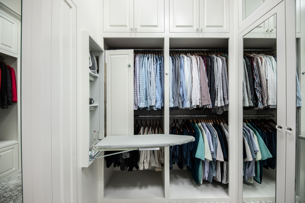 Large classic gender neutral walk-in wardrobe in Dallas with beaded cabinets, white cabinets, carpet, grey floors and a vaulted ceiling.
