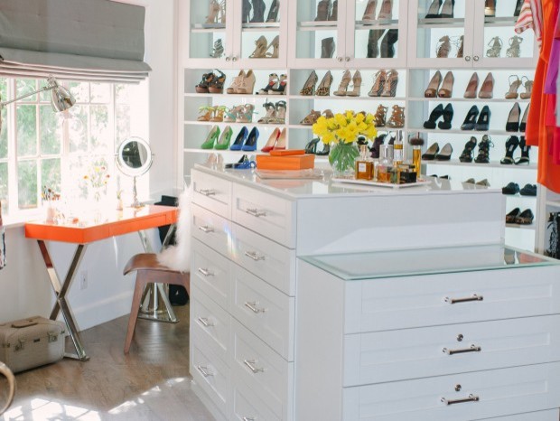This is an example of a traditional women's walk-in wardrobe in Los Angeles with white cabinets, shaker cabinets and light hardwood floors.