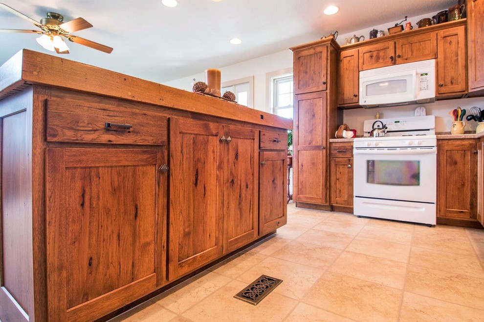 Inspiration for a mid-sized rustic u-shaped laminate floor eat-in kitchen remodel in Cincinnati with a drop-in sink, recessed-panel cabinets, medium tone wood cabinets, wood countertops, white appliances, an island and brown countertops