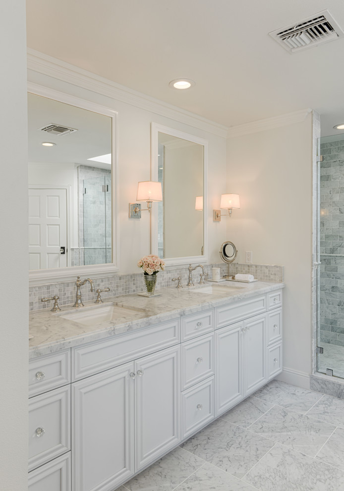 This is an example of a traditional master bathroom in Los Angeles with beaded inset cabinets, white cabinets, a freestanding tub, an alcove shower, gray tile, marble, white walls, marble floors, an undermount sink, marble benchtops, grey floor, a hinged shower door and grey benchtops.