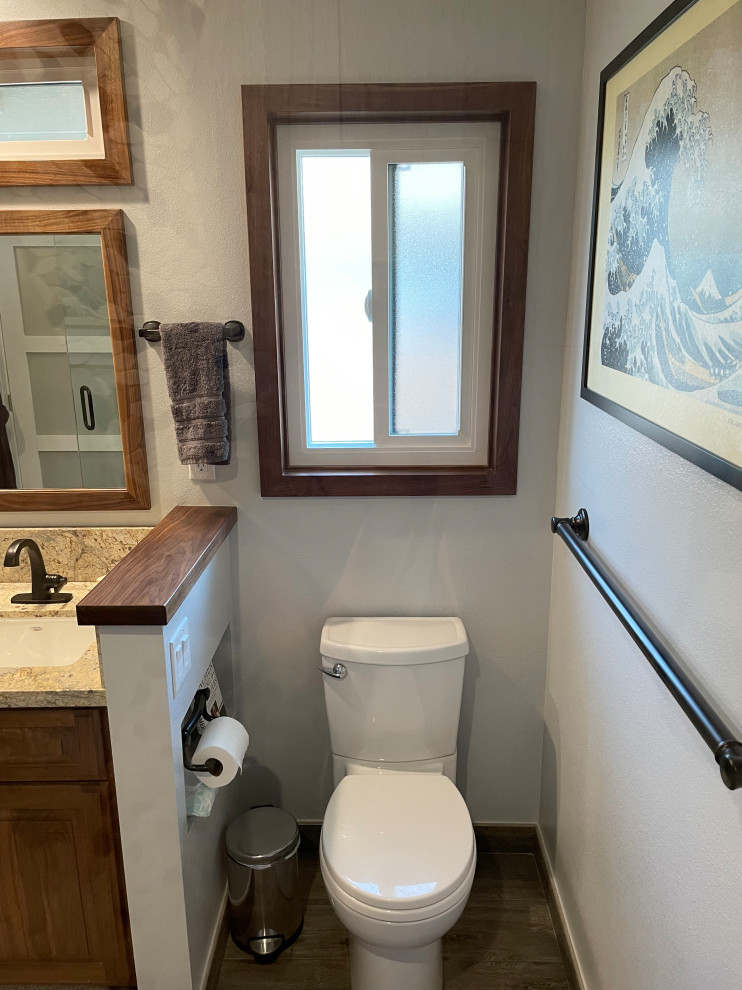 Medium sized classic cloakroom in Other with raised-panel cabinets, medium wood cabinets, a two-piece toilet, beige tiles, porcelain tiles, grey walls, porcelain flooring, a submerged sink, granite worktops, brown floors, beige worktops and a built in vanity unit.