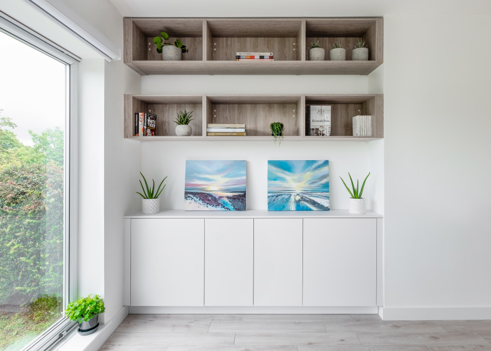 Esempio di un soggiorno design di medie dimensioni e aperto con pareti bianche, pavimento in gres porcellanato, porta TV ad angolo e pavimento beige