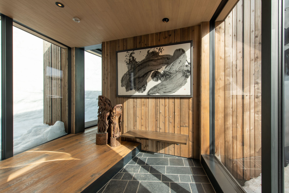 Imagen de hall beige rústico grande con paredes grises, suelo de granito, puerta simple, puerta gris, suelo negro, madera y todos los tratamientos de pared