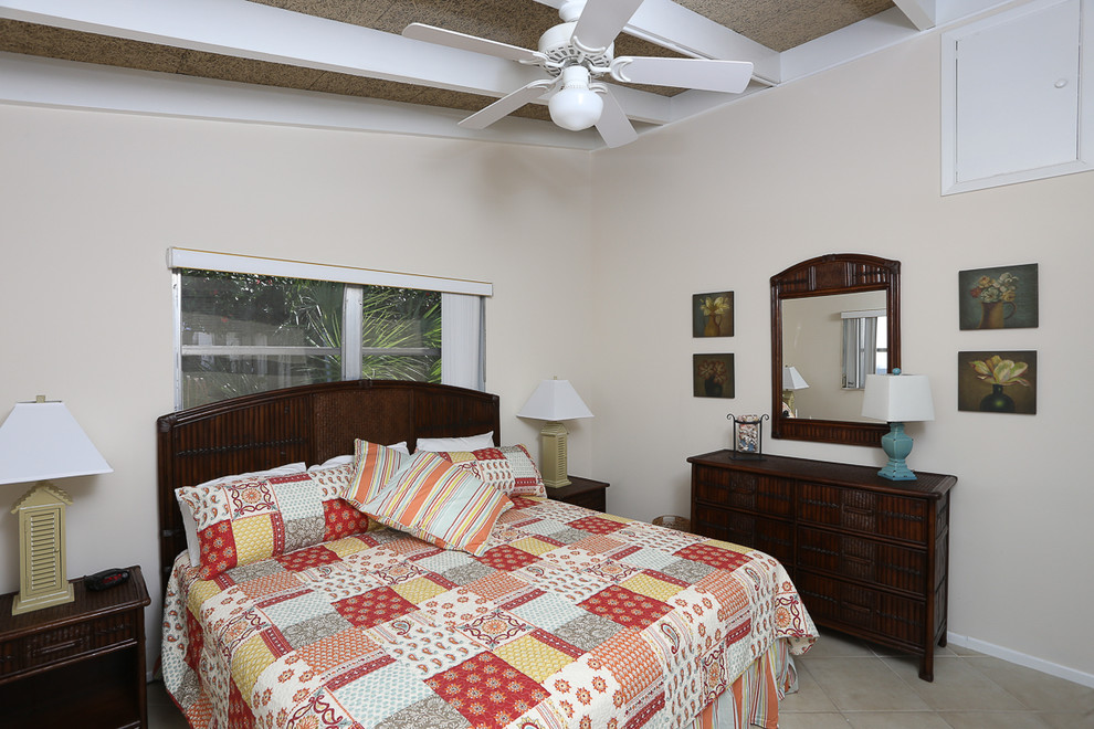 Beach style master bedroom in Tampa with beige walls and linoleum floors.