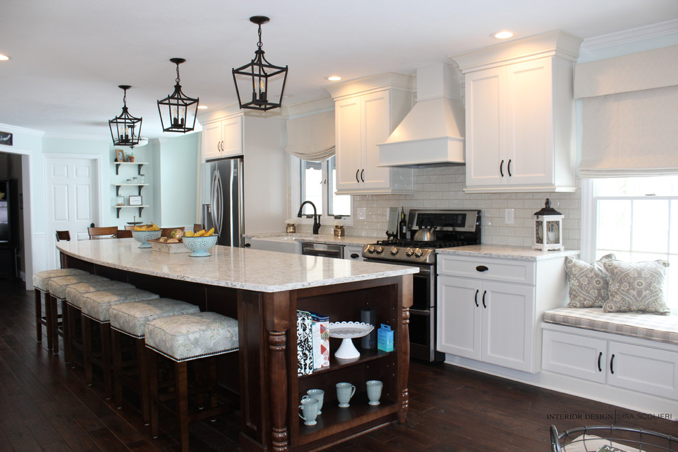 Large mountain style single-wall dark wood floor and brown floor eat-in kitchen photo with a farmhouse sink, shaker cabinets, white cabinets, quartz countertops, white backsplash, ceramic backsplash, stainless steel appliances and an island