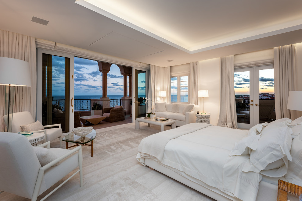 Design ideas for a large beach style master bedroom in Miami with white walls, carpet, no fireplace, a stone fireplace surround and yellow floor.