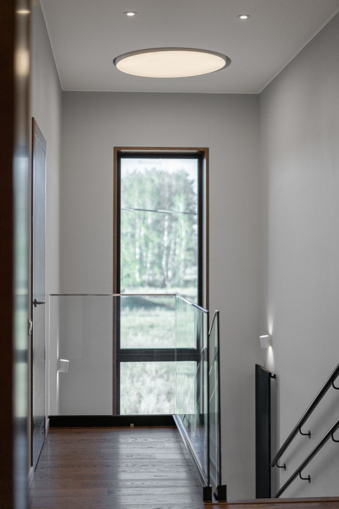 Стильный дизайн: коридор среднего размера в современном стиле с белыми стенами, паркетным полом среднего тона и коричневым полом - последний тренд