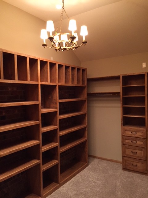 Inspiration for a large country walk-in wardrobe in Houston with light wood cabinets and carpet.