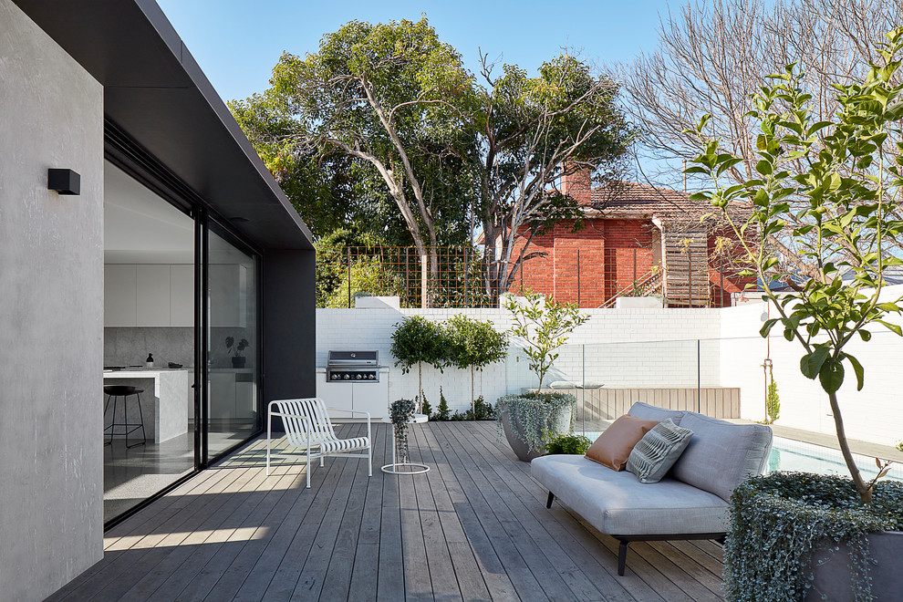 Large contemporary one-storey concrete grey house exterior in Melbourne with a flat roof and a metal roof.
