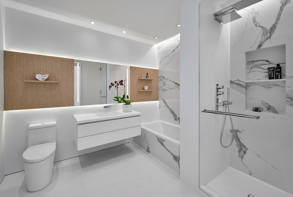 This is an example of a mid-sized contemporary master bathroom in Chicago with black and white tile, white tile, flat-panel cabinets, white cabinets, an alcove tub, an alcove shower, white walls, an integrated sink, white floor and white benchtops.