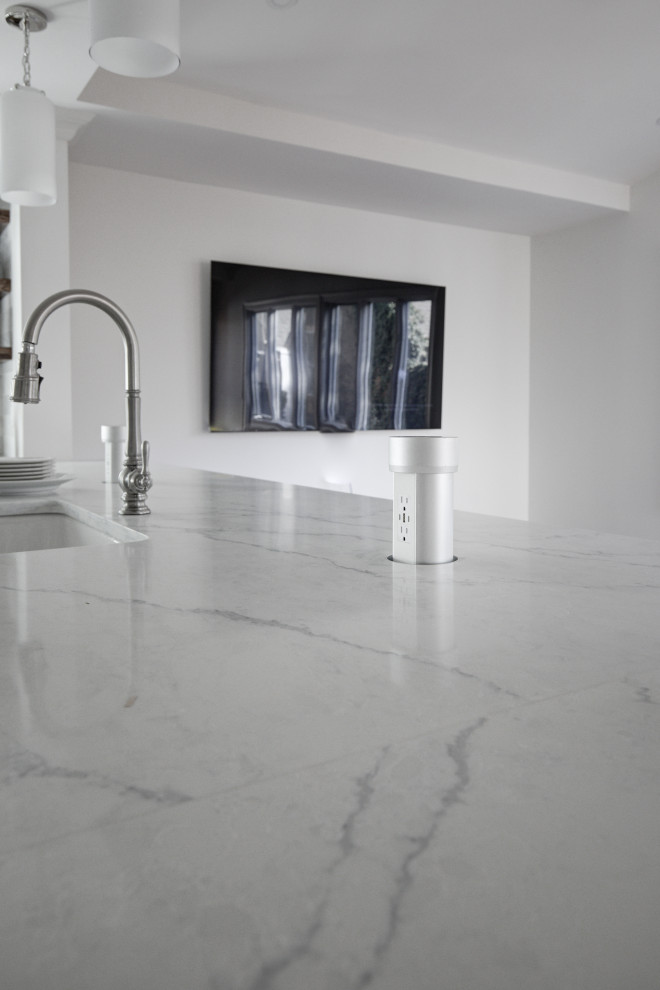 Inspiration for a mid-sized transitional u-shaped medium tone wood floor and brown floor open concept kitchen remodel with a farmhouse sink, recessed-panel cabinets, white cabinets, quartz countertops, multicolored backsplash, marble backsplash, stainless steel appliances, a peninsula and white countertops