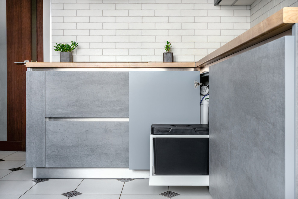This is an example of a mid-sized industrial l-shaped separate kitchen in Moscow with a drop-in sink, flat-panel cabinets, grey cabinets, laminate benchtops, brick splashback, coloured appliances, ceramic floors, no island and white floor.