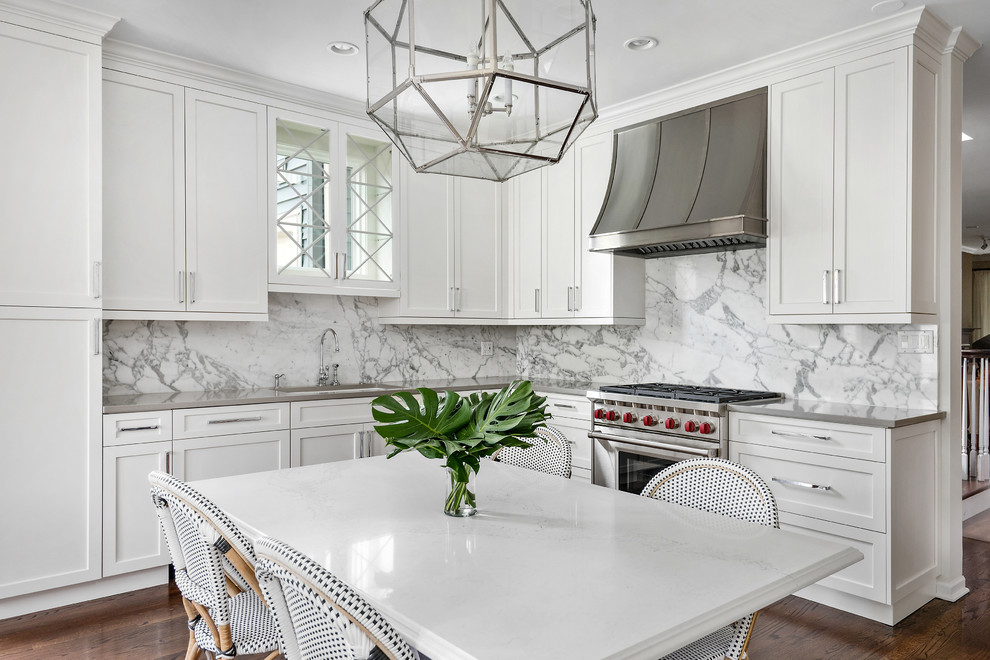 Inspiration for a mid-sized transitional l-shaped eat-in kitchen in Chicago with an undermount sink, white cabinets, solid surface benchtops, white splashback, stone slab splashback, shaker cabinets, dark hardwood floors and no island.