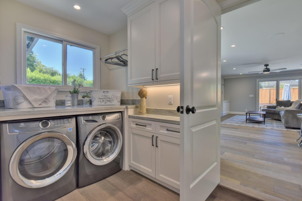 Photo of a small contemporary utility room in San Francisco with shaker cabinets, white cabinets, quartzite benchtops, grey walls, linoleum floors, a side-by-side washer and dryer, grey floor and green benchtop.