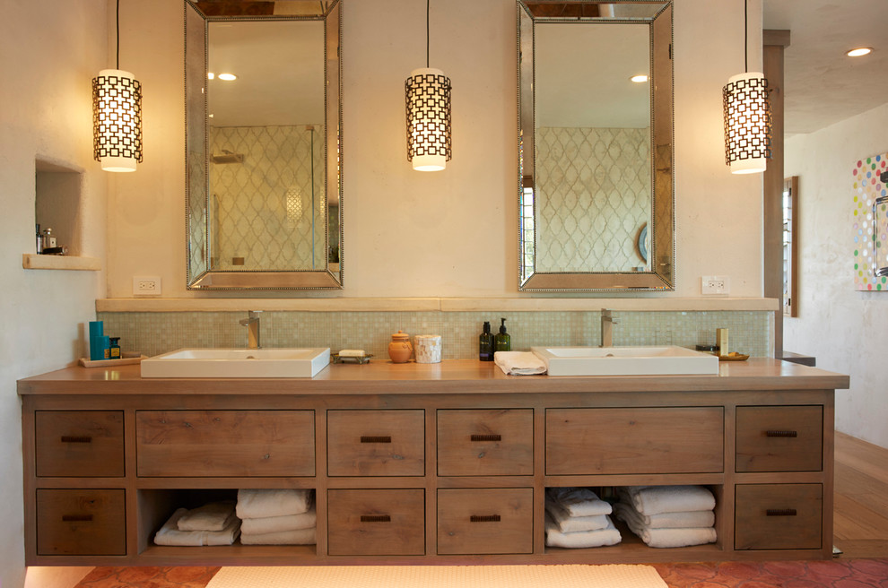 Photo of a mid-sized beach style master bathroom in San Luis Obispo with flat-panel cabinets, distressed cabinets, green tile, glass tile, beige walls, terra-cotta floors, a vessel sink, wood benchtops and red floor.