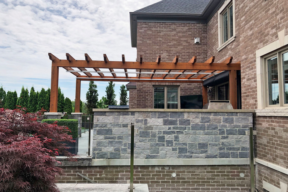 Photo of a contemporary backyard patio in Toronto with concrete pavers and a pergola.