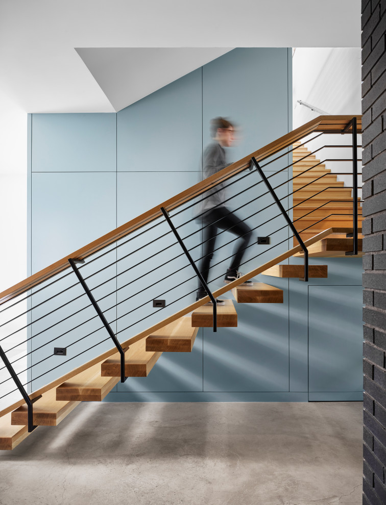Идея дизайна: лестница в стиле ретро с деревянными ступенями, перилами из смешанных материалов, панелями на части стены и кладовкой или шкафом под ней без подступенок