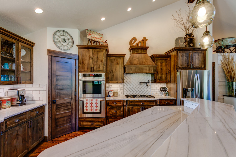 Mid-sized mountain style u-shaped medium tone wood floor kitchen pantry photo in Seattle with shaker cabinets, white cabinets, quartzite countertops, white backsplash, subway tile backsplash, stainless steel appliances and an island