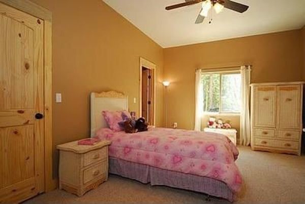 Bedroom and large mountain style girl carpeted kids' bedroom photo with beige walls