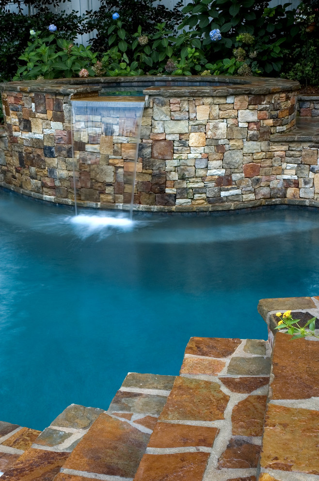 Design ideas for a mid-sized traditional backyard custom-shaped natural pool in Atlanta with a hot tub and concrete pavers.