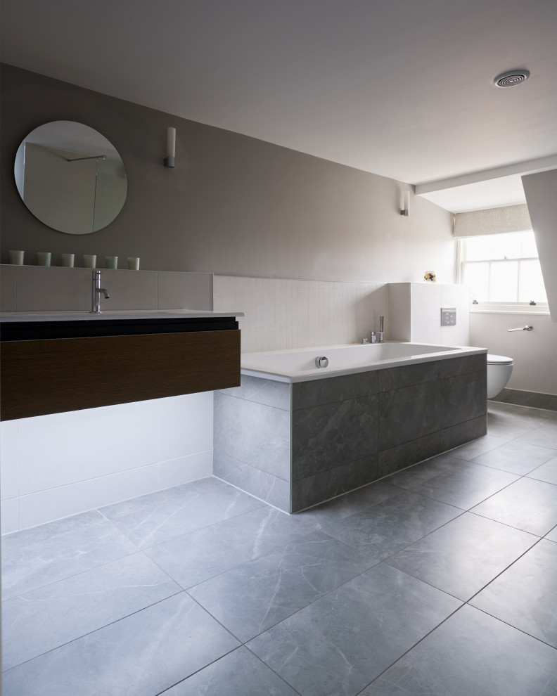 Bathroom - mid-sized traditional master gray tile and ceramic tile ceramic tile, gray floor and single-sink bathroom idea in Other with flat-panel cabinets, gray cabinets, a one-piece toilet, beige walls, a console sink and a floating vanity