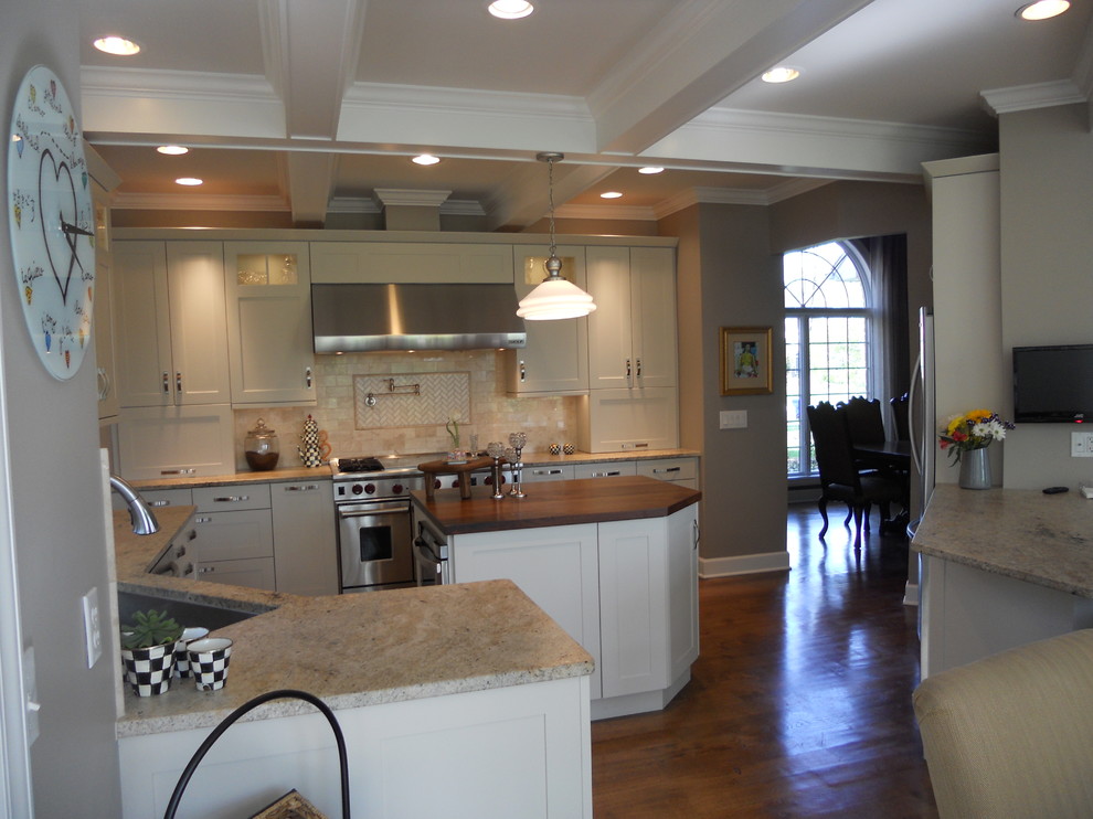 Inspiration for a large transitional u-shaped medium tone wood floor eat-in kitchen remodel in New York with an undermount sink, recessed-panel cabinets, white cabinets, granite countertops, multicolored backsplash, porcelain backsplash, stainless steel appliances, gray walls and an island