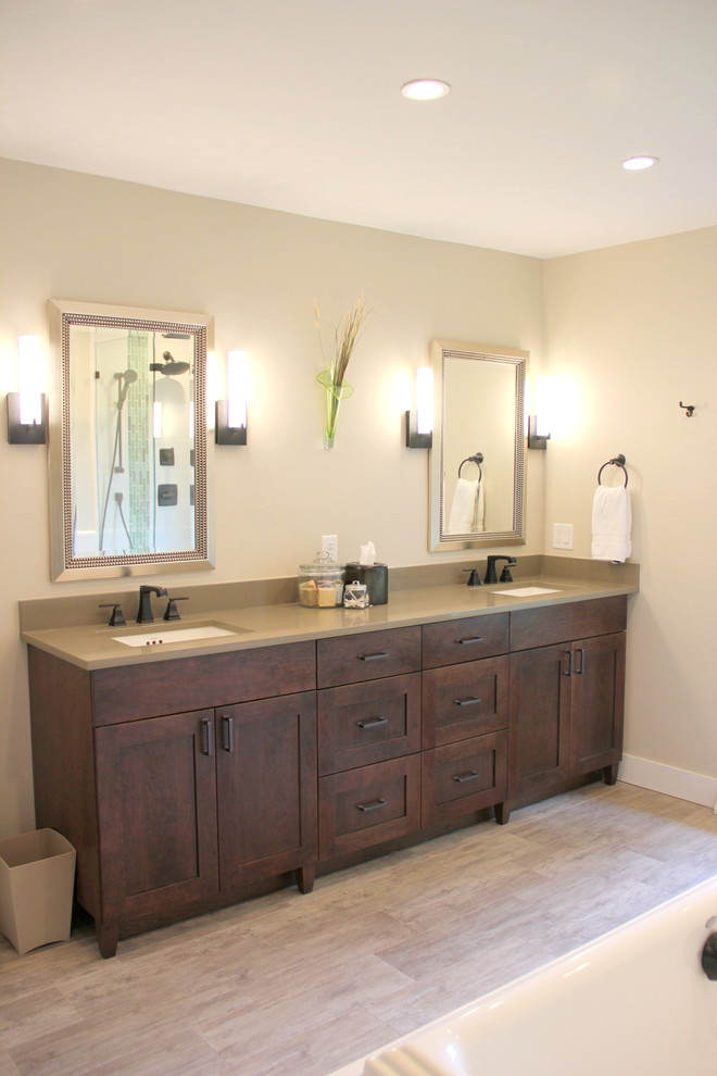 This is an example of a large transitional master bathroom in Denver with shaker cabinets, dark wood cabinets, a drop-in tub, an alcove shower, blue tile, white tile, mosaic tile, beige walls, laminate floors, an undermount sink, quartzite benchtops, beige floor, a hinged shower door and grey benchtops.