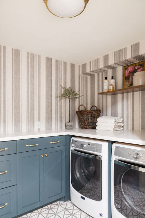 Mid-sized transitional l-shaped dedicated laundry room in Salt Lake City with blue cabinets, a side-by-side washer and dryer, multi-coloured floor and white benchtop.