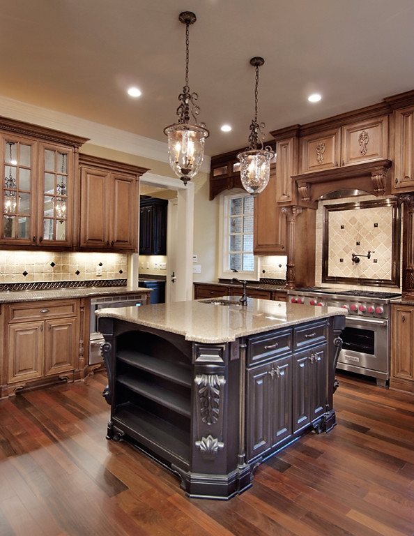 Inspiration for a large traditional u-shaped open plan kitchen in Atlanta with a drop-in sink, medium wood cabinets, granite benchtops, beige splashback, stone tile splashback, stainless steel appliances, medium hardwood floors, with island, raised-panel cabinets and brown floor.