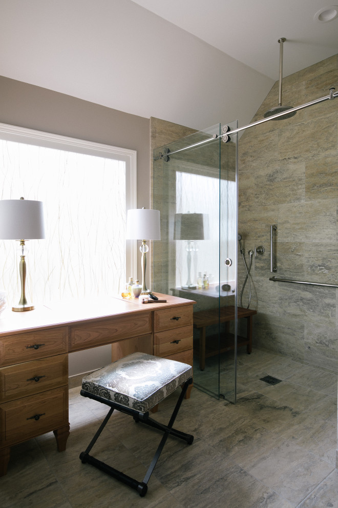 Exempel på ett stort klassiskt beige beige en-suite badrum, med luckor med upphöjd panel, bruna skåp, en kantlös dusch, beige kakel, travertinkakel, beige väggar, travertin golv, ett undermonterad handfat, marmorbänkskiva, beiget golv och dusch med skjutdörr