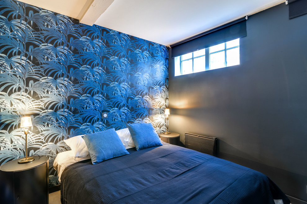 Inspiration for a small tropical master bedroom in Marseille with blue walls, laminate floors and grey floor.