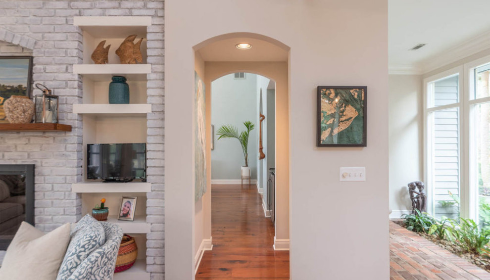 This is an example of a mid-sized beach style hallway in Atlanta with beige walls, dark hardwood floors and brown floor.