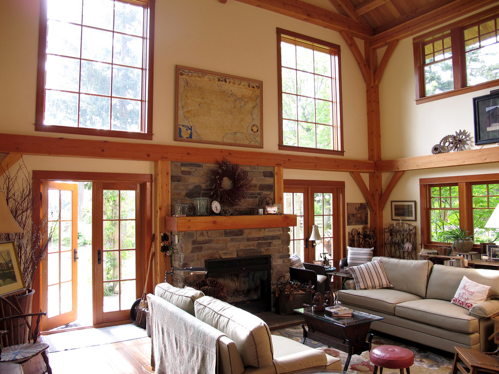 Design ideas for a traditional living room in Seattle with beige walls, a standard fireplace, a stone fireplace surround, no tv and brown floor.