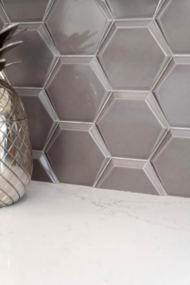 Inspiration for a small transitional u-shaped porcelain tile and beige floor home design remodel with an undermount sink, recessed-panel cabinets, white cabinets, quartz countertops, beige backsplash, ceramic backsplash, stainless steel appliances and white countertops