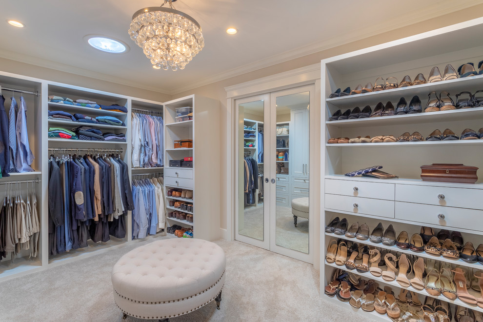 This is an example of a large transitional dressing room in Los Angeles with recessed-panel cabinets, white cabinets, carpet and beige floor.